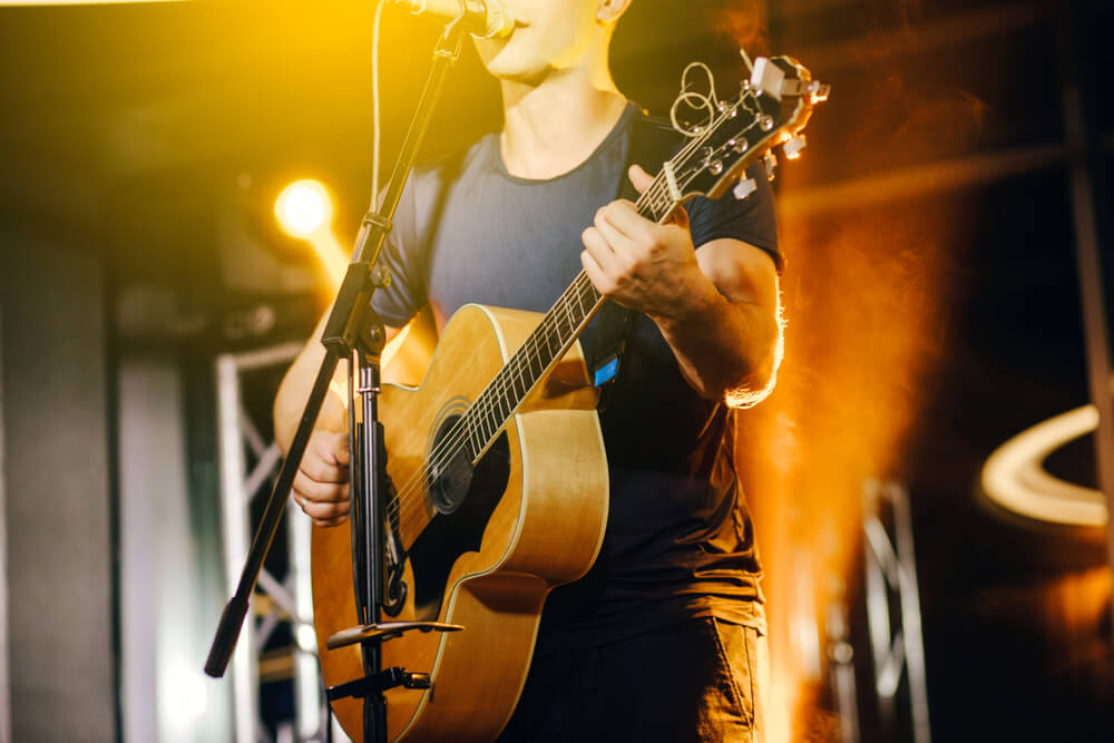 Person on stage with a guitar: live music in Panama City Beach